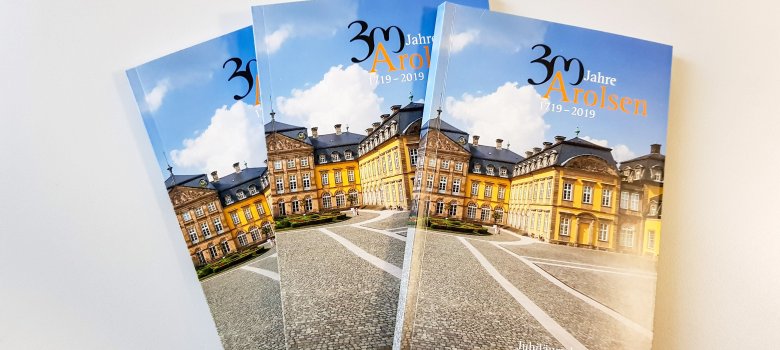 Jubiläumsbuch 300 Jahre Arolsen drei Ausgaben des Jubiläumsbuchs 300 Jahre Arolsen lieben aufgefächert nebeneinander