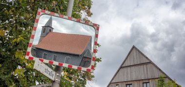 Spiegelung der Kirche Wetterburg in einem Verkehrsspiegel