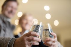 Personen halten zwei Gläser Wasser in die Kamera