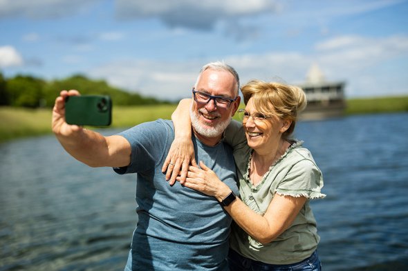 zwei Personen machen ein Selfie von sich mit dem Twistesee im Hintergrund