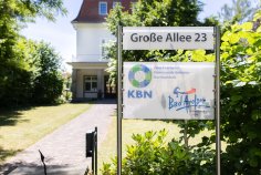 Zweckverband Kommunale Betriebe Nordwaldeck Hinweisschild vor dem Gebäude der KBN mit der Aufschrift Große Allee 23 Zweckverband Kommunale Betriebe Nordwaldeck dem Logo der KBN und Bad Arolser Nahwärme GmbH mit Logo