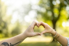 zwei Personen halten die Hände aneinander und formen daraus ein Herz