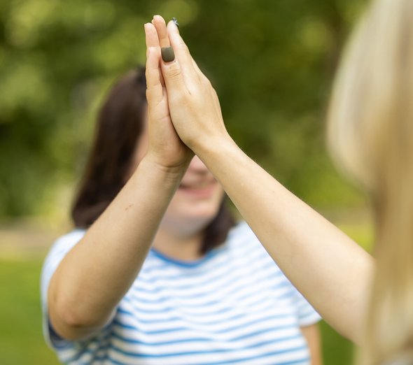 Abklatschen zwei Personen geben sich ein High Five