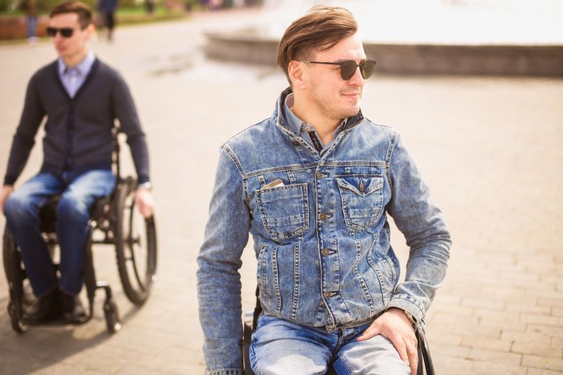 Zwei Männer im Rollstuhl in einem Park